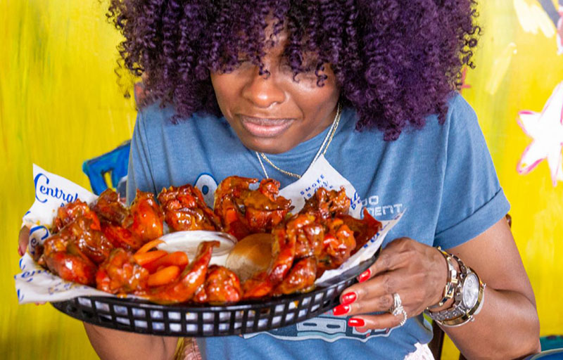 woman with a basket full of saucy wings