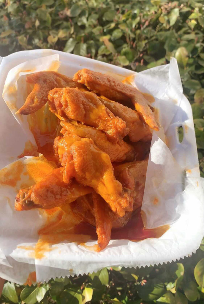 a container of wings surrounded by plants 