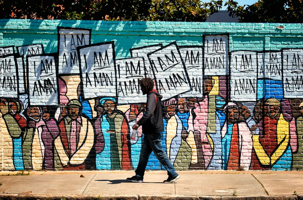 A man walking past a mural