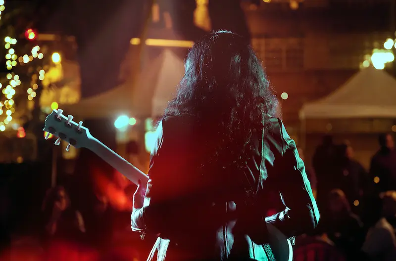 Live music artist standing on stage with a guitar