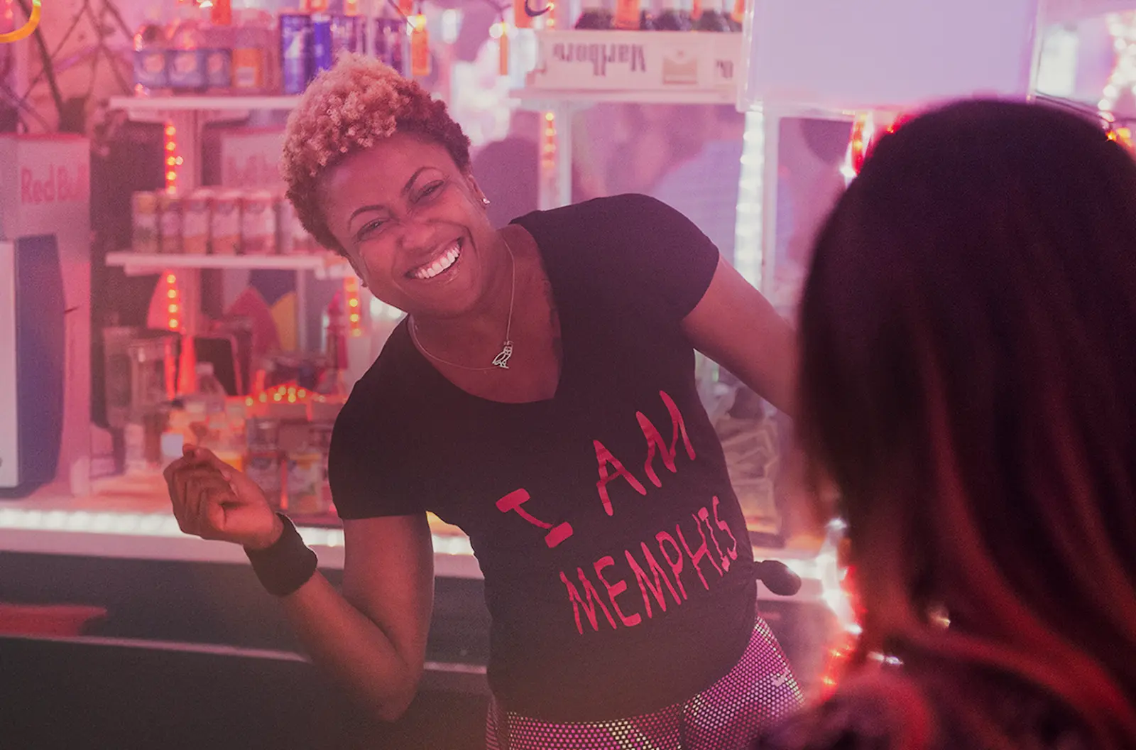 A smiling bartender wearing a I am Memphis shirt