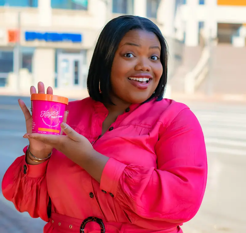 Young, black, female entrepreneur holding her product