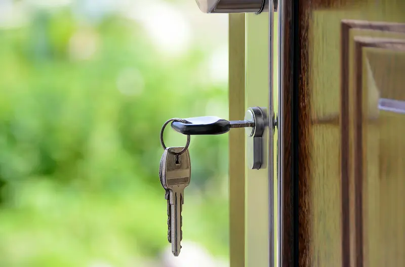 A key and keychain hanging from a door lock